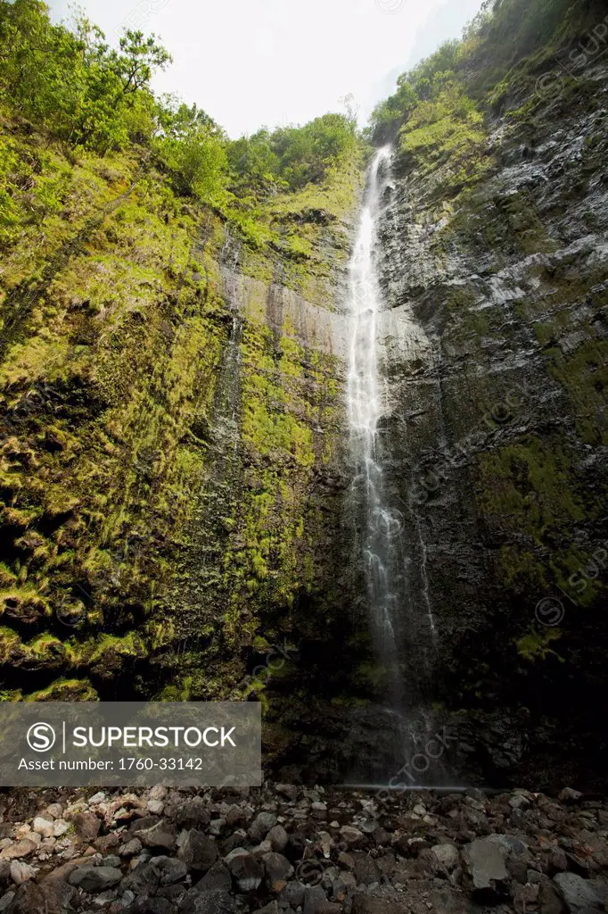 Hawaii, Maui, Hana, Waimoku Falls Surrounded By Lush Greenery And Rocks.