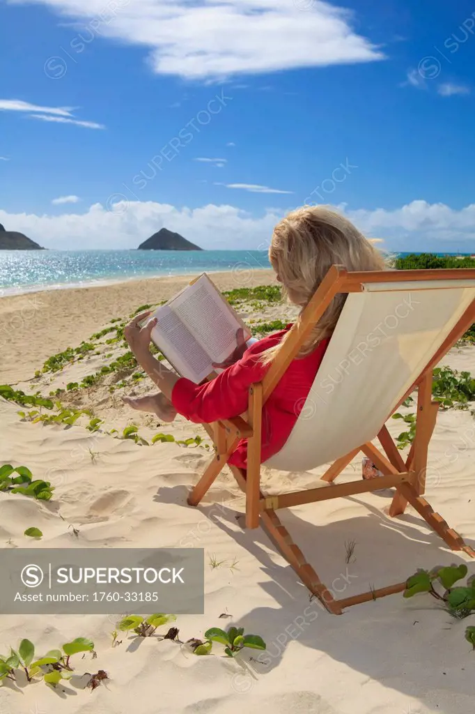 Hawaii, Oahu, Lanikai Beach, Woman Reading A Book On White Sandy Beach.