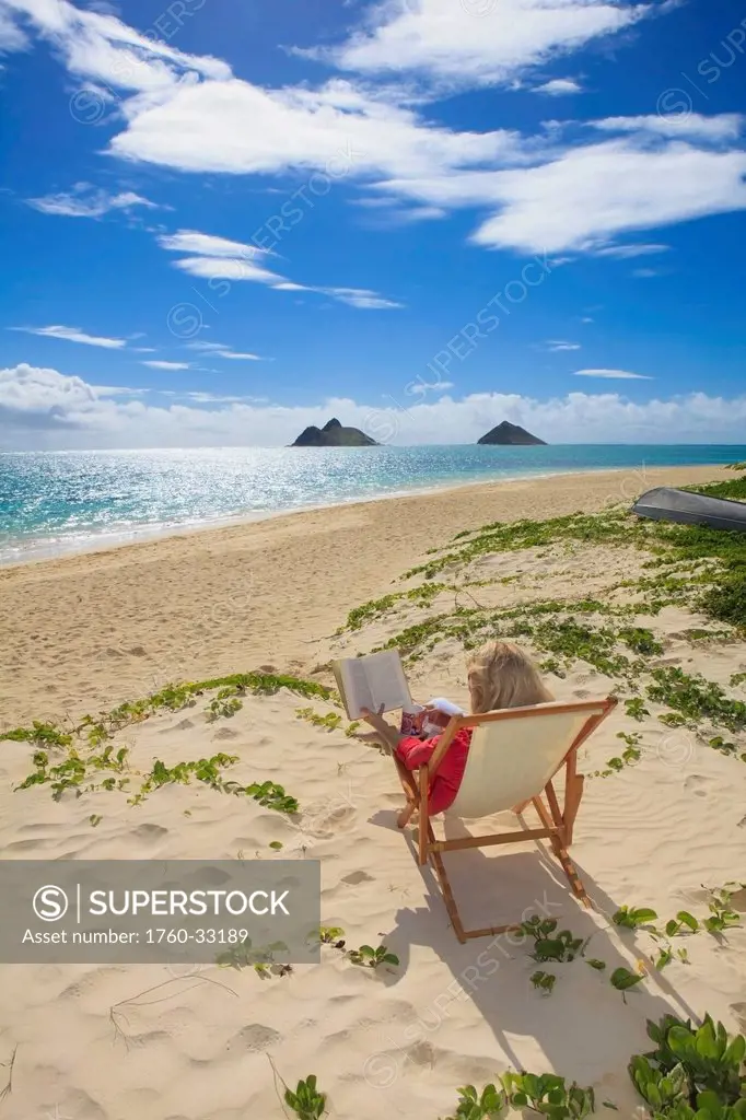 Hawaii, Oahu, Lanikai Beach, Woman Reading A Book On White Sandy Beach.