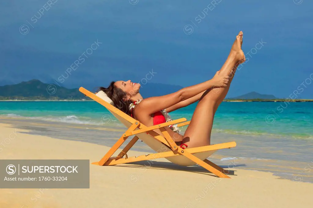 Hawaii, Oahu, Kailua, Lanikai, Beautiful Woman Stretches In A Lounge Chair On The Beach.