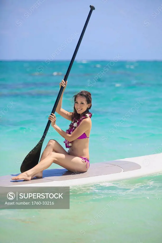 Hawaii, Oahu, Young Woman Posing On Paddle Board In Ocean.