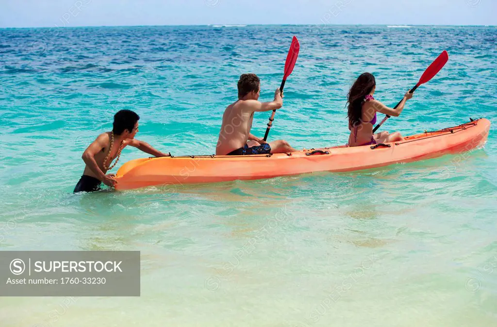 Hawaii, A Beachboy Helps A Young Couple Begin Kayaking