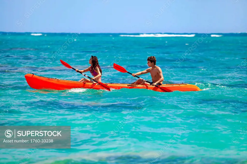 Hawaii, A Young Couple Paddling Their Kayak.