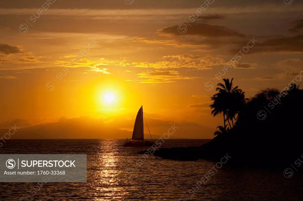Hawaii, Maui, Makena, A Silhouette Of A Sailboat At Sunset.