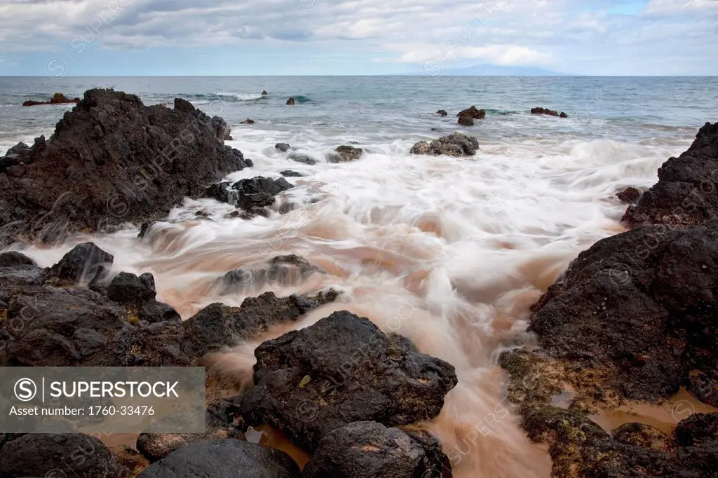 Hawaii, Maui, Makena, Soft water crashes on lava rocks on the beach