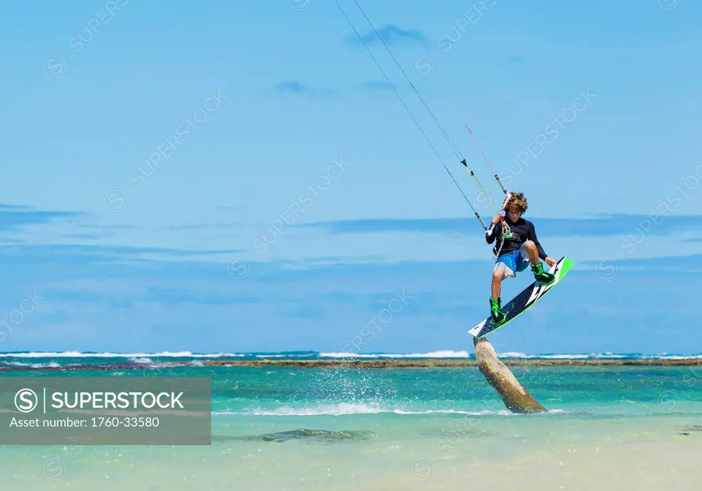 Hawaii, Maui, Professional Kiteboarder, Jesse Richman riding right over a tree stump in ocean. EDITORIAL USE ONLY.