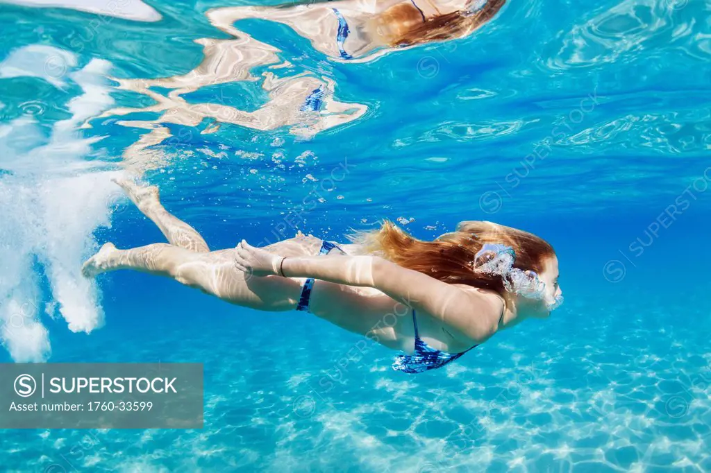 Hawaii, Lanai, Manele Bay, Young woman swimming near ocean surface.