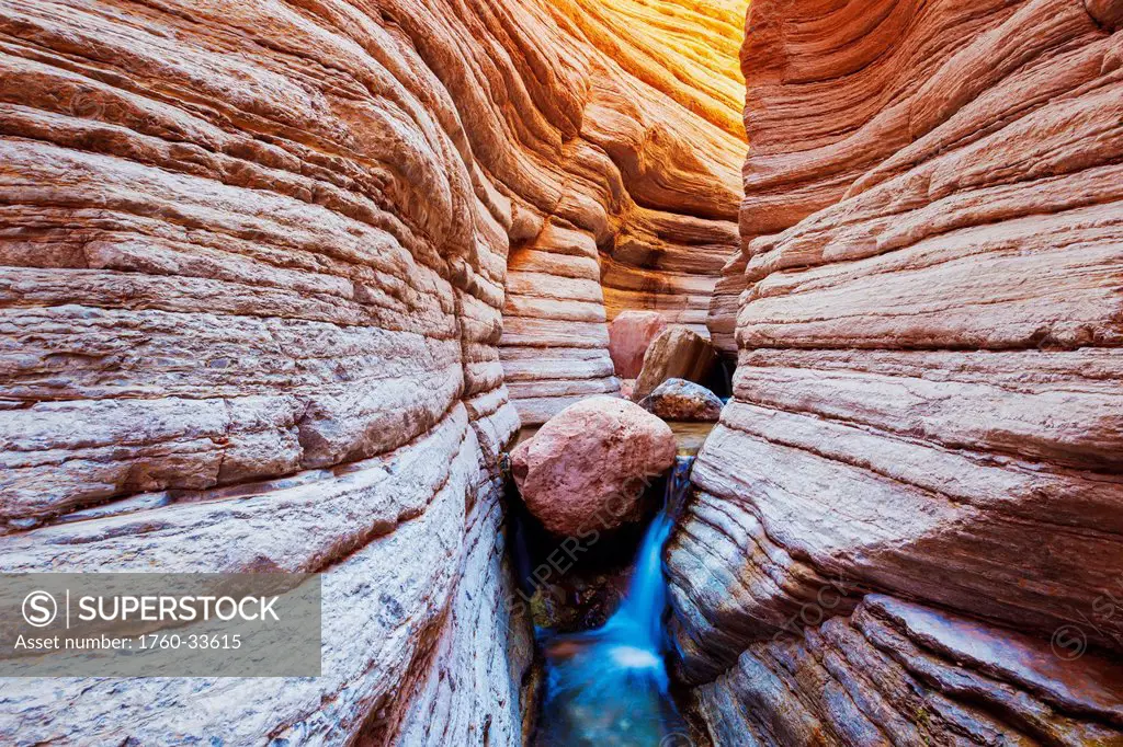 Arizona, Grand Canyon National Park, Matkatamiba Slot Canyon, Flowing stream among amazing rock formations.
