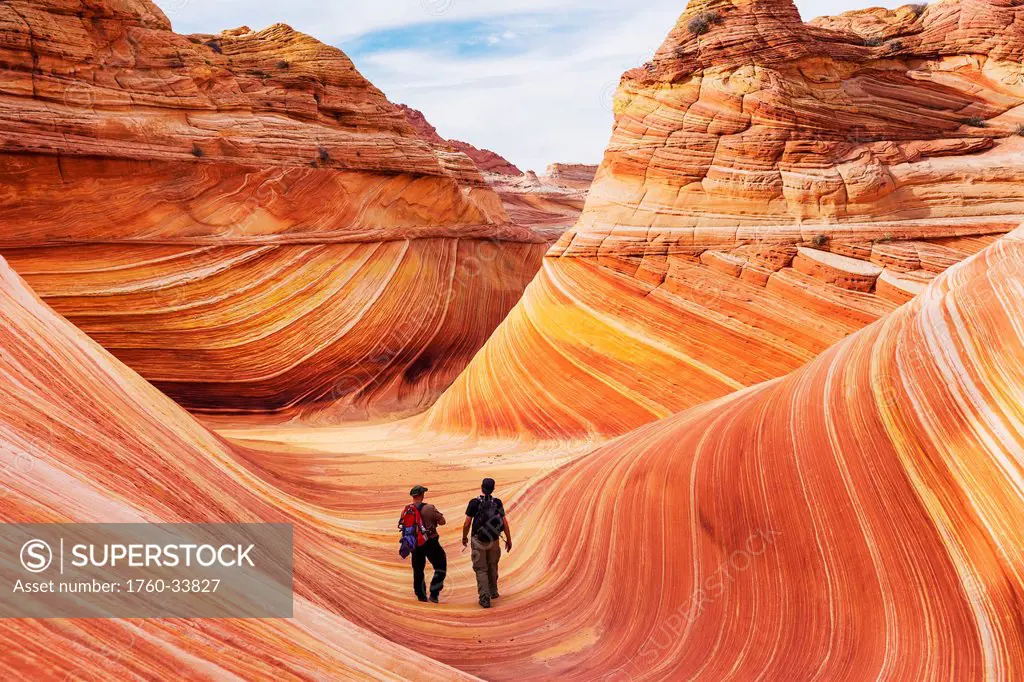 Arizona, Page, North Coyote Buttes, Two hikers explore the rock formation called The Wave.