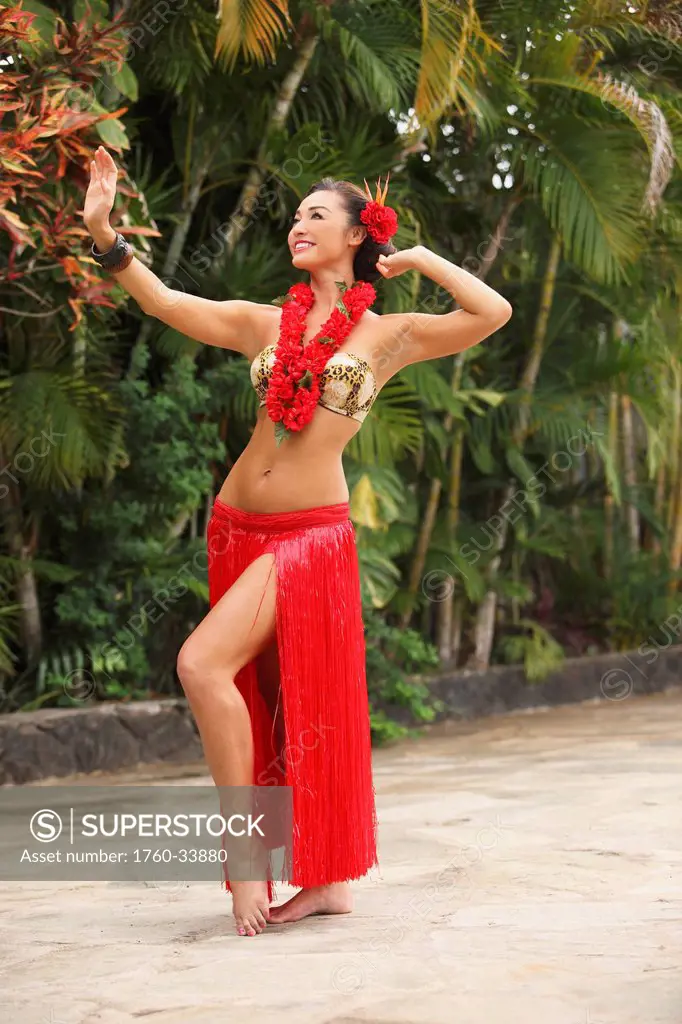 Hawaii, A local Hawaiian woman wearing a red lei and dancing the hula.