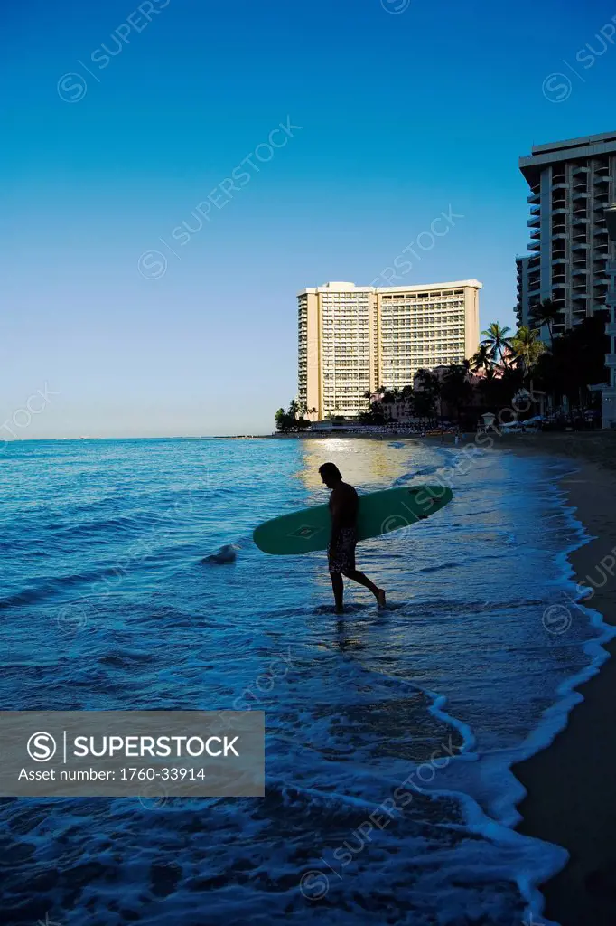 Surfer at dawn on Waikiki Beach; Oahu, Hawaii, United States of America