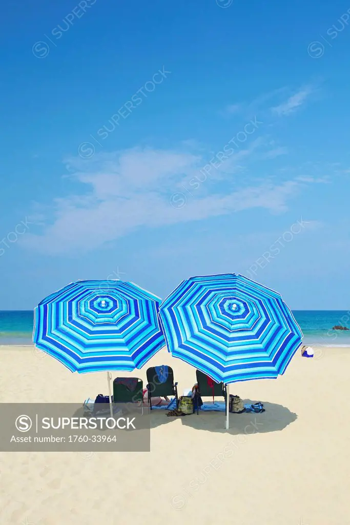 Beach chairs and blue umbrellas on the beach; Wailua, Hawaii, United States of America