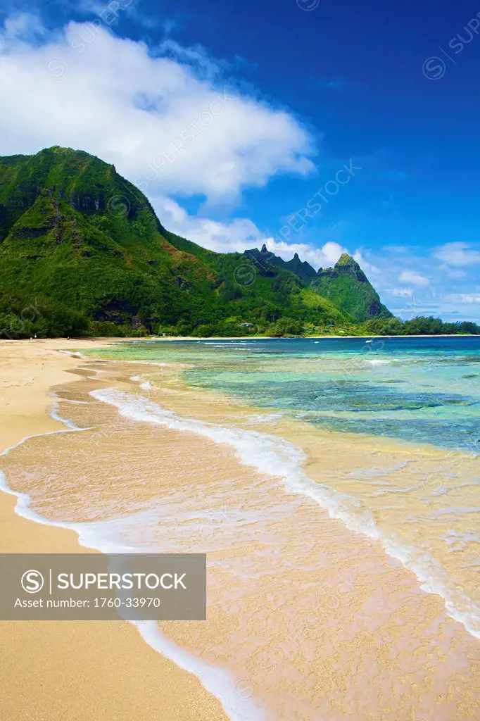 Water washing up onto the sand along the coast; Wailua, Hawaii, United States of America