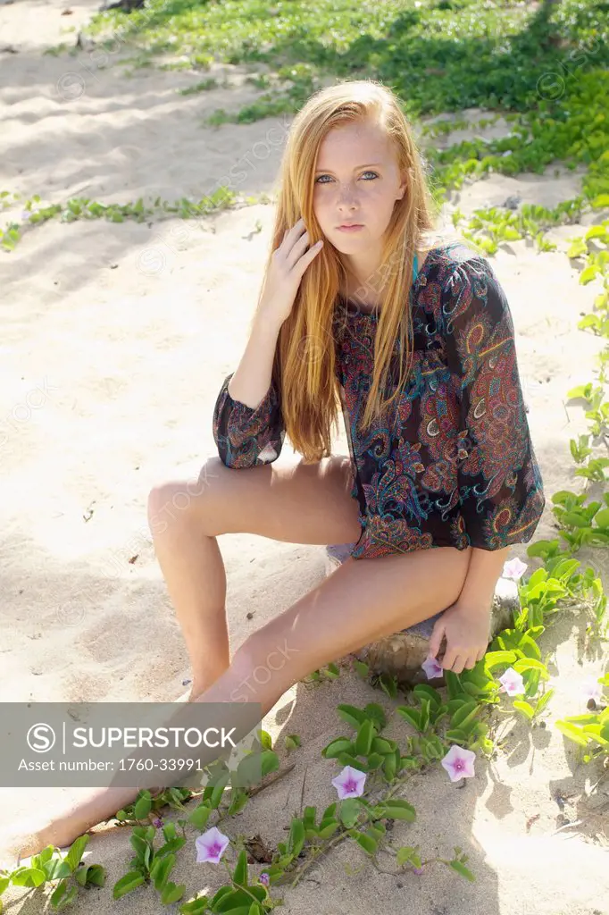 Portrait of a young woman with long red hair on Tunnel's beach; Kauai, Hawaii, United States of America