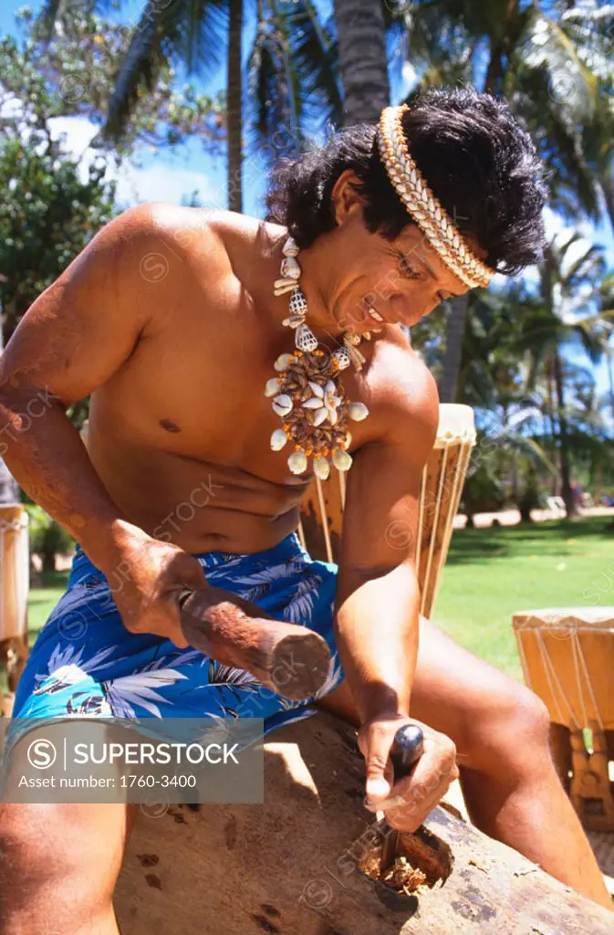 Closeup of local man with shell haku and necklace, making pau drum