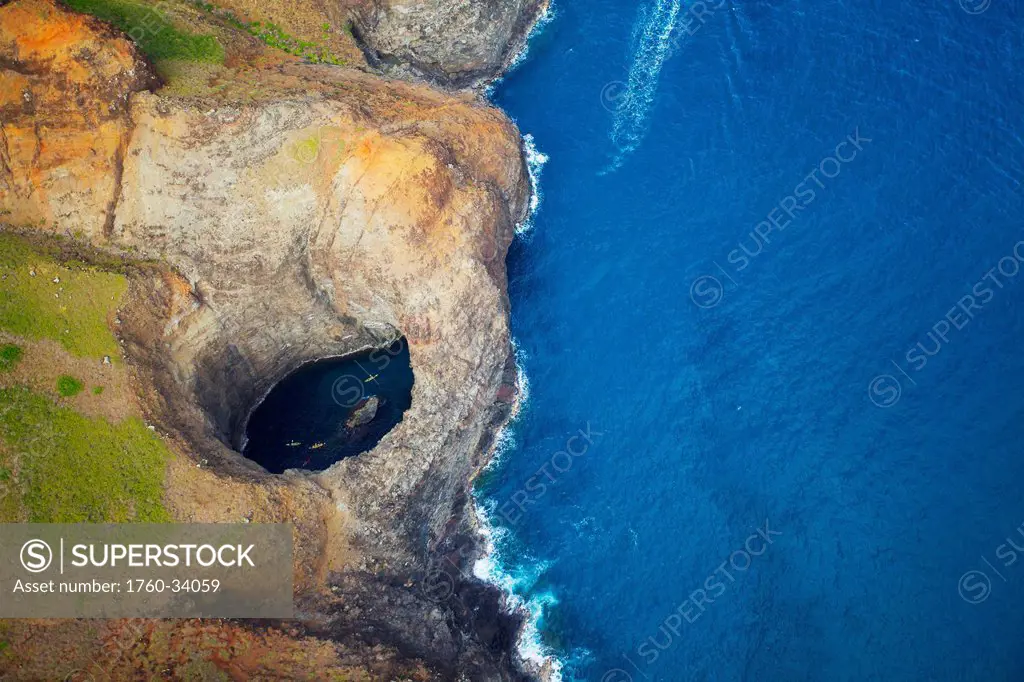 Aerial view of the rugged coastline and tide pool in a hole along an hawaiian island; Hawaii, United States of America