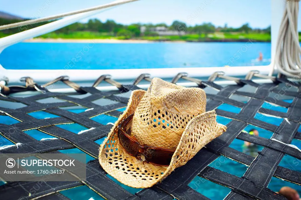 A sunhat on the hammock of a catamaran off the coast of an hawaiian island; Hawaii, United States of America
