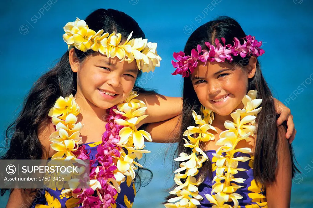 Two smiling girls with arms around each other, plumeria and orchid leis C1486