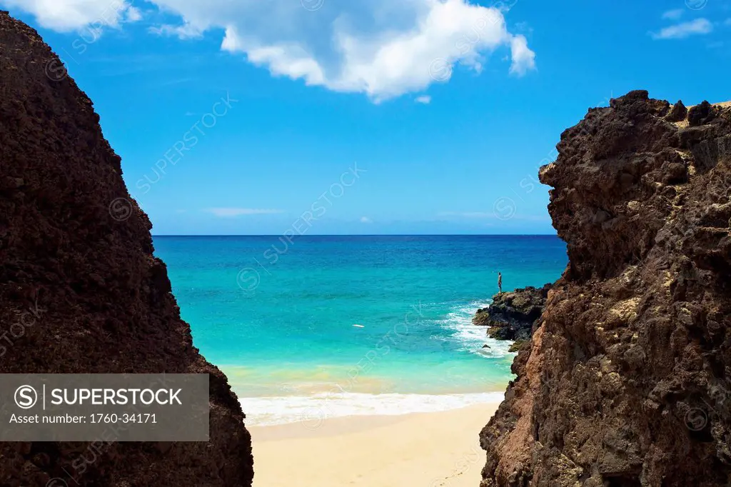 A person standing on the rugged rocks on the coast of an hawaiian island; Hawaii, United States of America