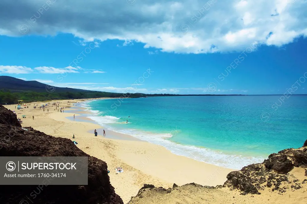 Sunbathers, swimmers and surfers on a hawaiian beach; Hawaii, United States of America