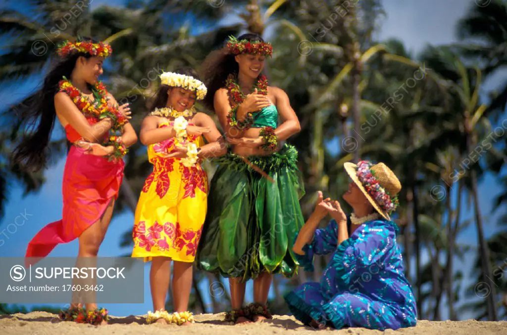Older Hawaiian woman (tutu) with three young hula girls on beach