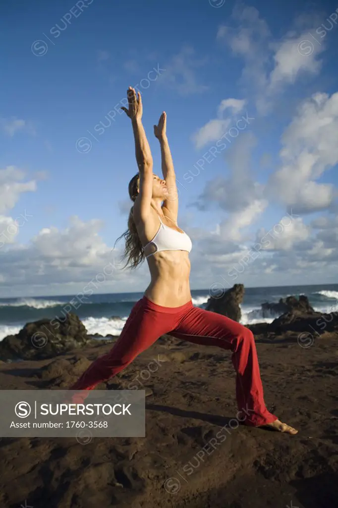 Hawaii, Maui, young woman doing yoga next to the ocean.