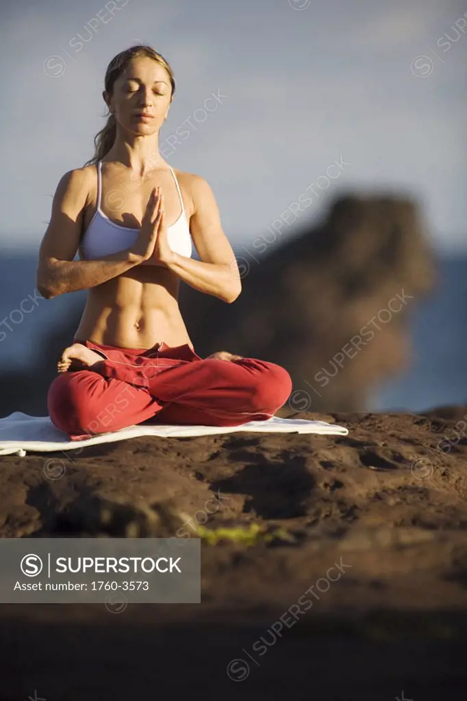 Hawaii, Maui, young woman doing yoga next to the ocean.