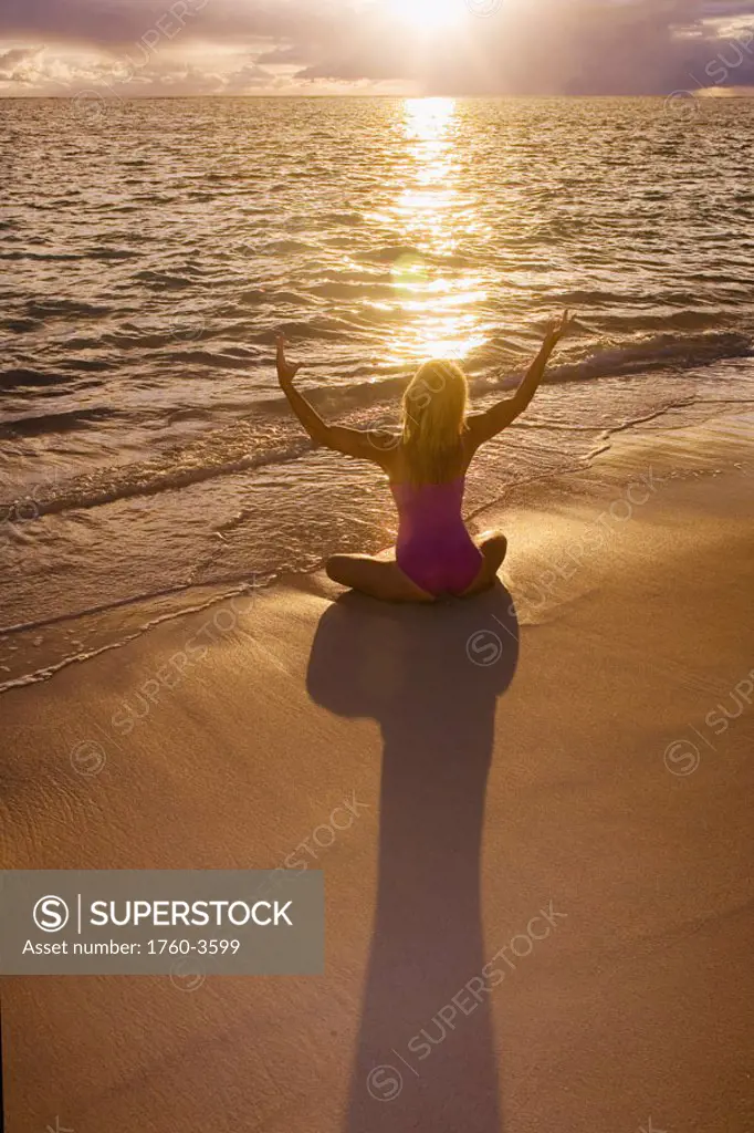 Hawaii, Oahu, Lanikai, woman doing yoga on the beach at sunrise.