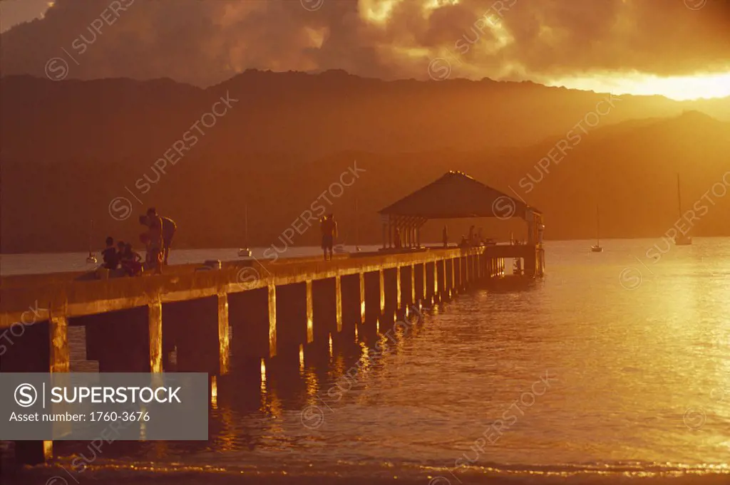 Hawaii Kauai Hanalei Bay pier w/ people fishing at sunset golden orange D1549 reflections