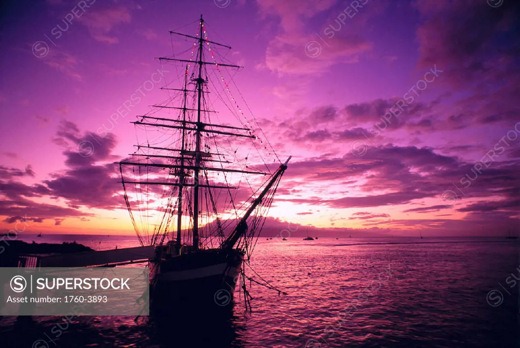 Hawaii Maui, Lahaina Harbor, Carthaginian tall ship at sunset, silhouetted A46A pink and yellow sky