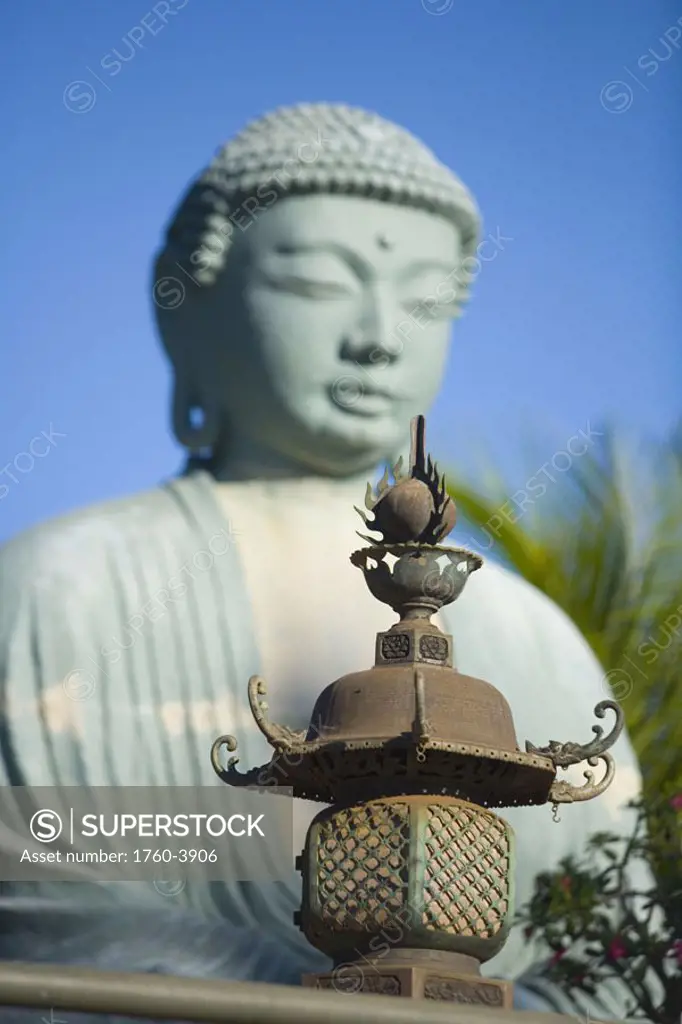 Hawaii, Maui, Lahaina Jodo Mission, Buddha statue blurred with focus on lantern in foreground
