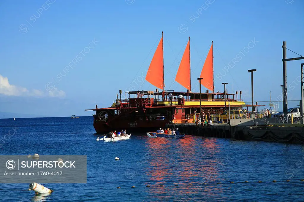Hawaii, Big Island, Kailua-Kona, Sunset cruise boat loads passengers at dock, three bright orange sails