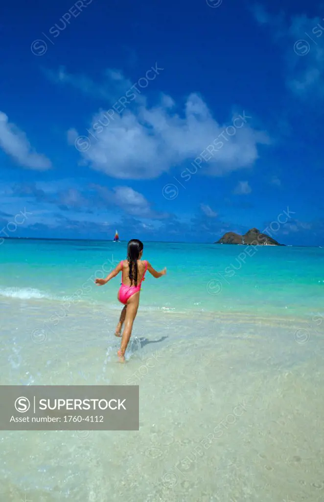 Hawaii, Oahu, Lanikai beach, Mokulua Islands, girl running into ocean, blue sky Hawaii
