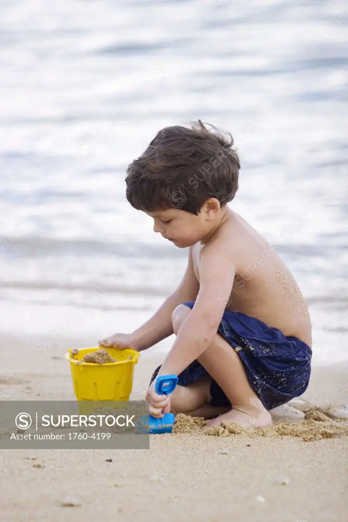 Hawaii, Maui, Spreckelsville, Baby Beach, Young boy playing in sand.