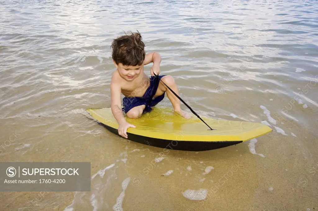 Hawaii, Maui, Spreckelsville, Baby Beach, Young boy playing in the water on a boogieboard