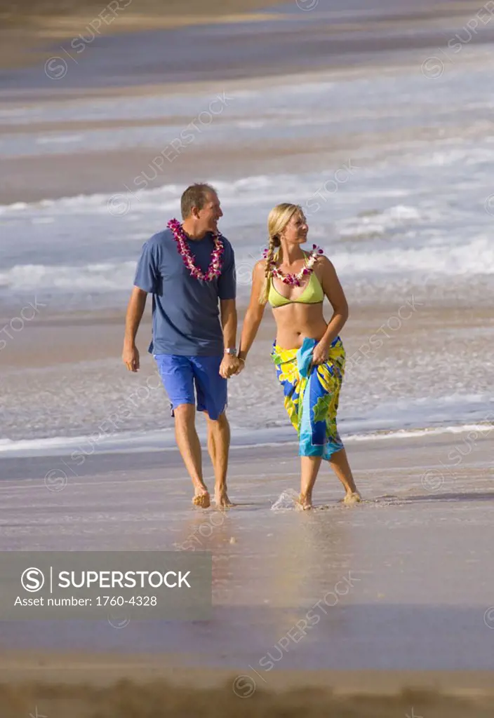 Hawaii, Maui, Baldwin Beach, Couple on vacation walking down the beach holding hands