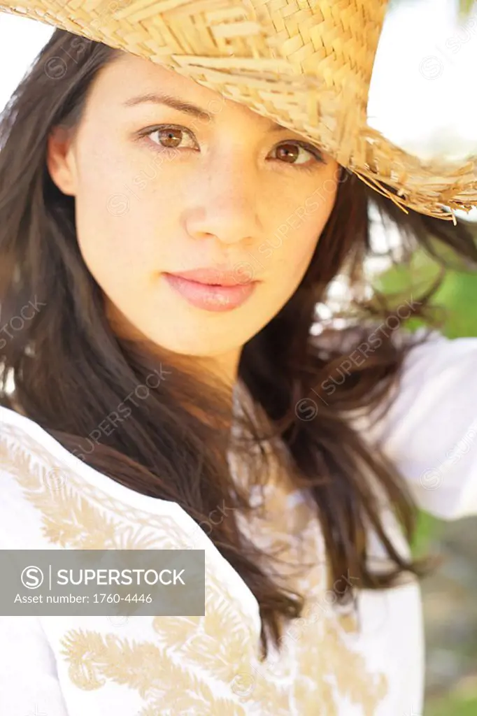 Beautiful young woman wearing a straw hat