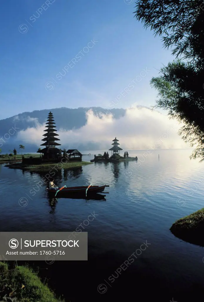 Indonesia, Bali, Ulu Danu temple at sunrise, canoe paddling on water NO MODEL RELEASE