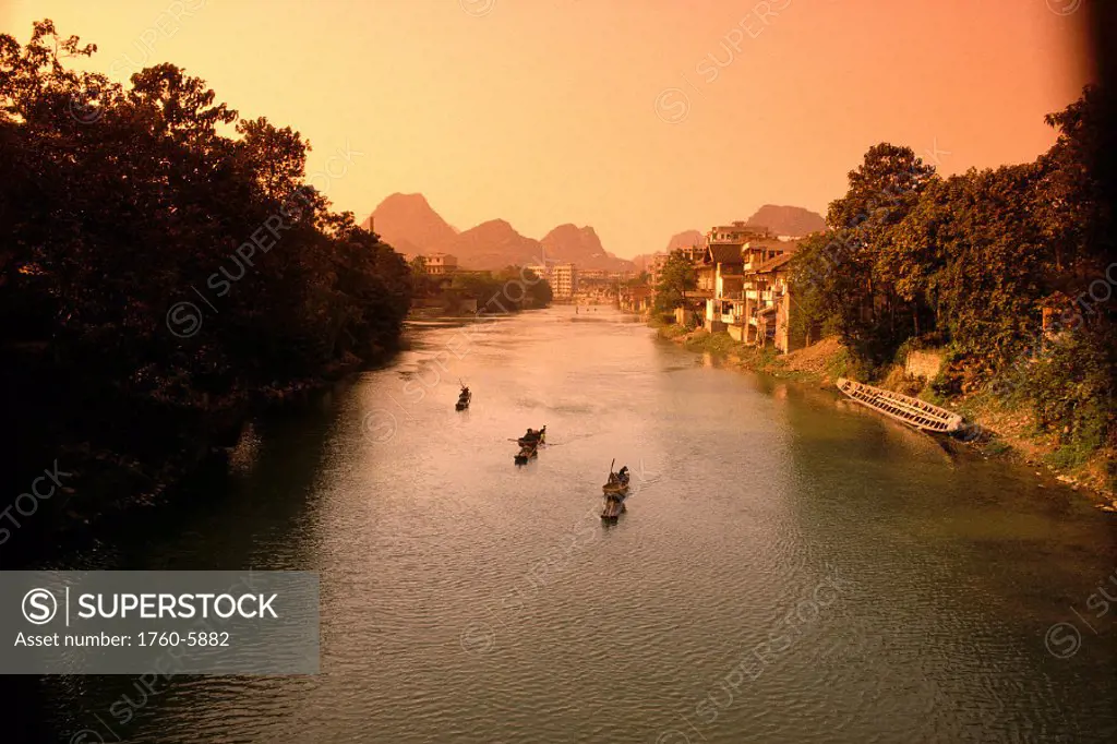China, Guilin, Fisherman on Li River, city in background B1790