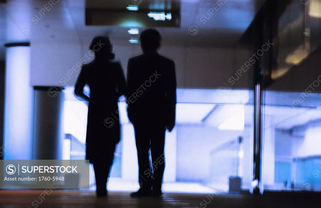 Hong Kong, Chinese couple silhouetted in building hallway, Blurred motion