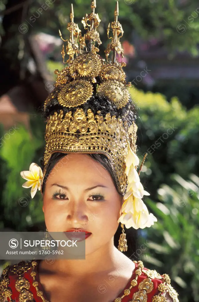 Cambodia, Siem Reap, Portrait of woman in traditional dancing costume, greenery in background.
