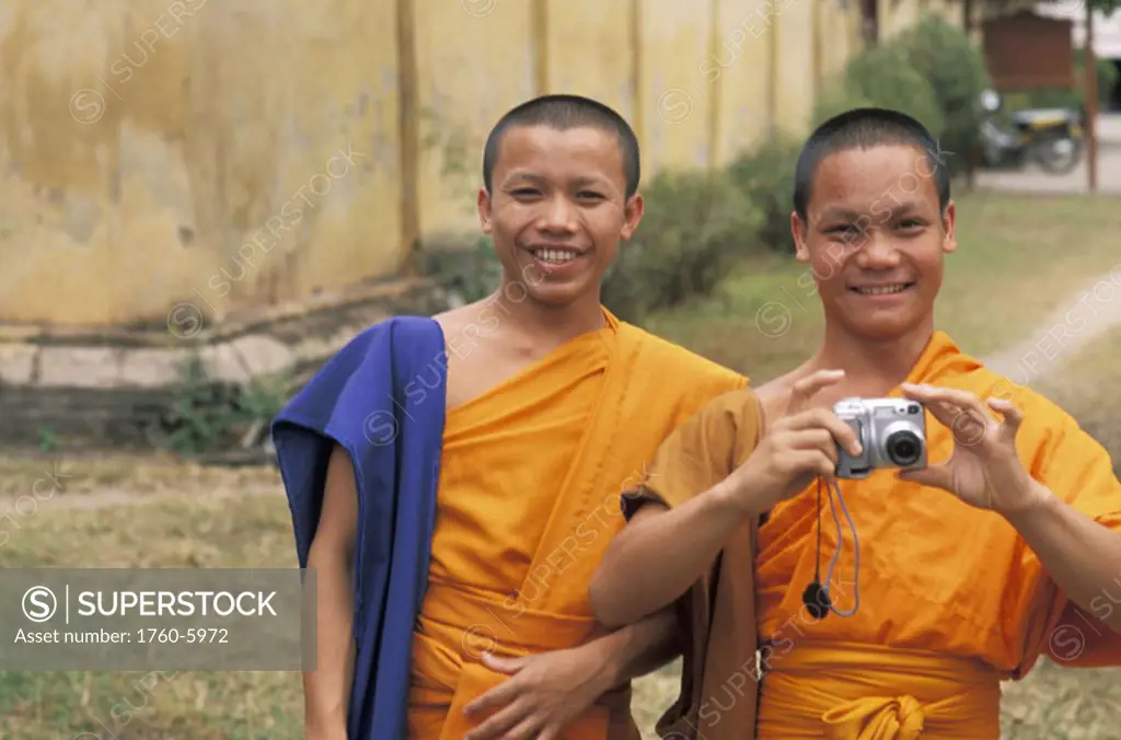 Laos, Vientiane, Si Saket Temple, Two young monks in front of building, enjoying camera.