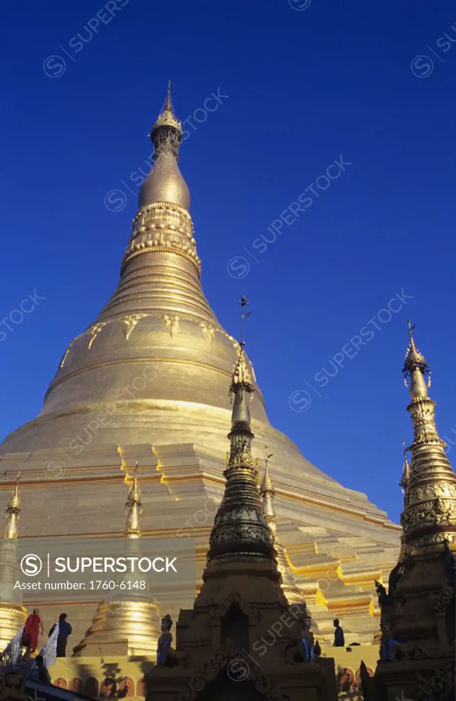 Burma (Myanmar), Yangon, Shwedagon Paya, Close-up of top of golden temple against blue sky.