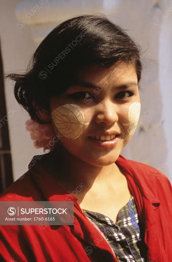 Burma (Myanmar), Portrait of Burmese woman with leaf shaped thanaka powder on cheeks.