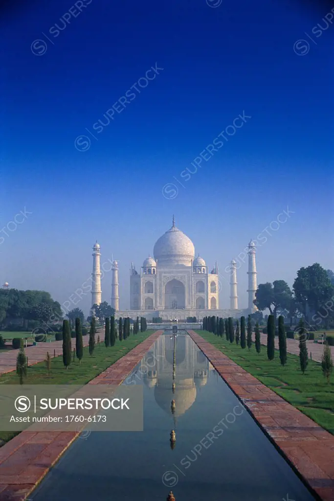 India, Agra, Taj Mahal view of exterior, reflections in water, misty blue sky C1896