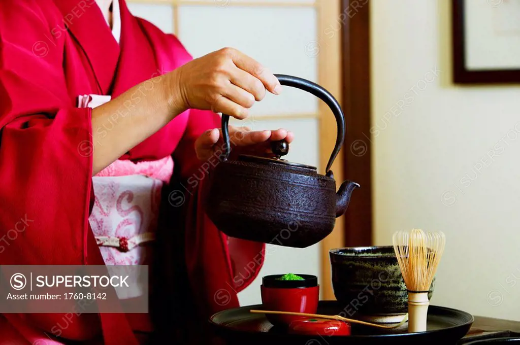 Close up of geisha pouring tea at tea ceremony.