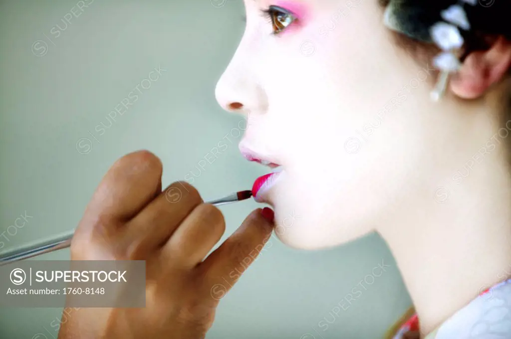 Japanese Maiko having her lipstick applied.