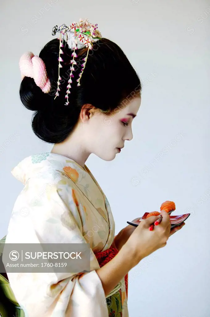 Portrait of traditional Japanese Maiko eating sushi.