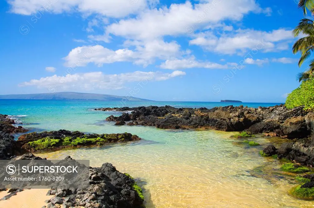 Hawaii, Maui, Makena, Maui Wai or Secret Beach, Shallow ocean water surrounded by rocks and sand.