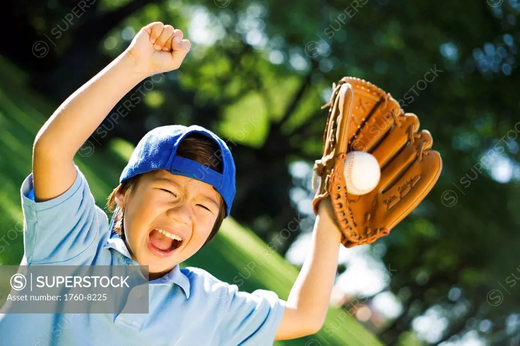 Young Japanese child playing with baseball.